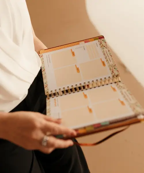 Foto ilustrativa do planner físico Meu Plano Perfeito, com divisões mensais e espaço para fé, vida pessoal, casa e trabalho